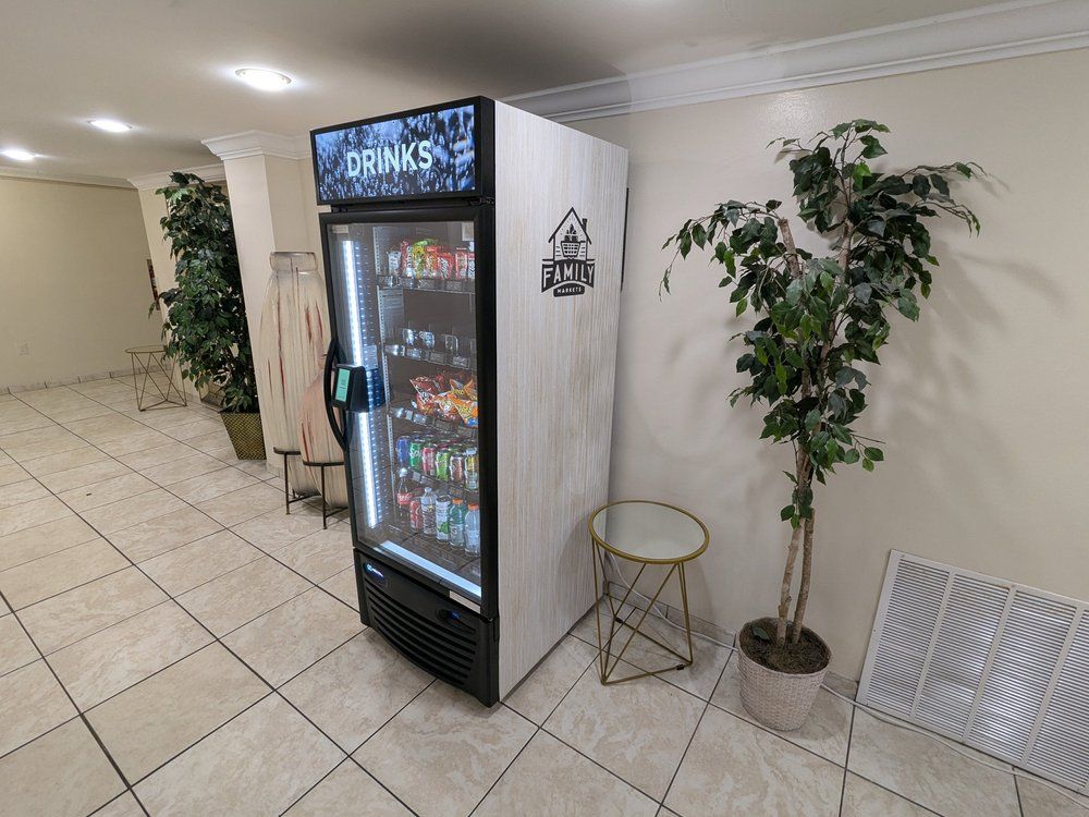 Single glass-door cooler stocked with drinks and snacks in a shared interior