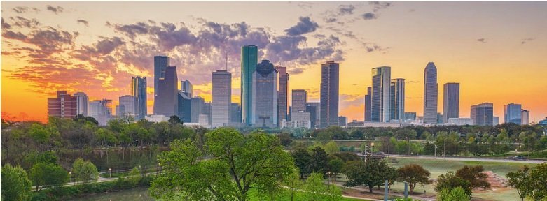 Houston skyline at sunset above green parkland