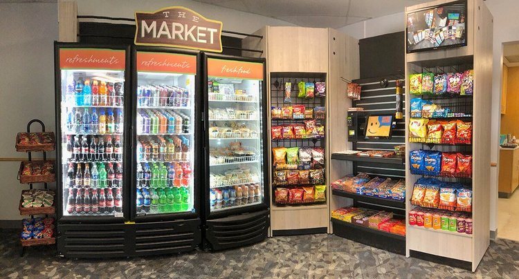 Open market with refrigerated cabinets, snack shelving and a self-checkout kiosk